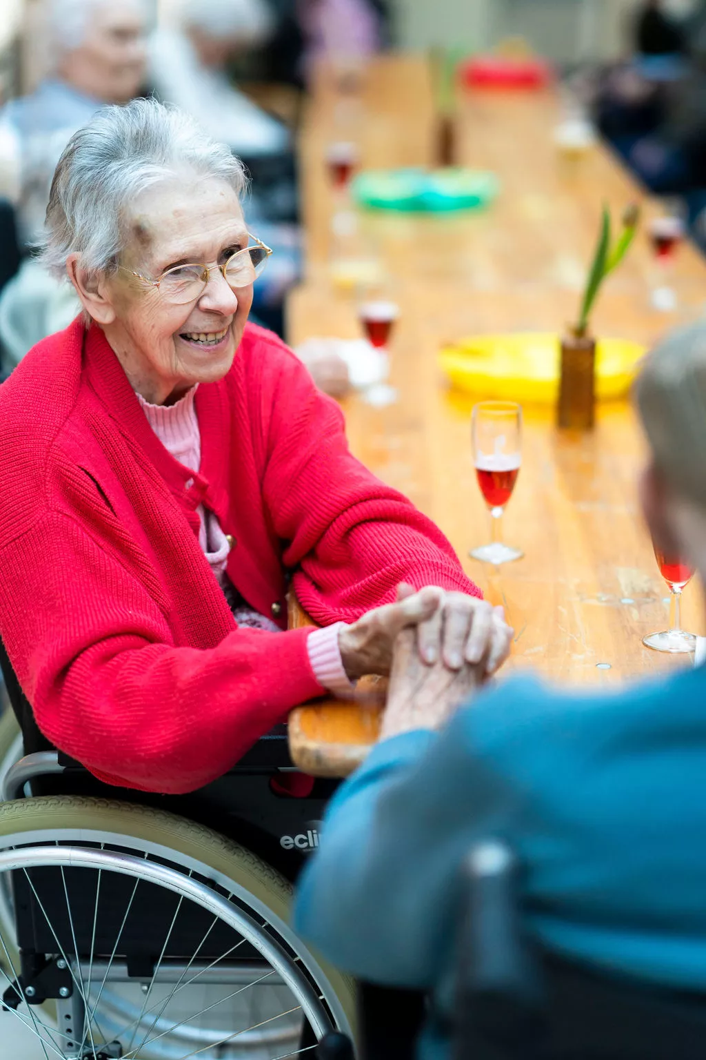 femme âgée assise à une table et tenant la main d'un homme âgé