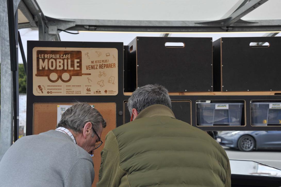 Deux personnes réparent un objet au Repair Café Mobile